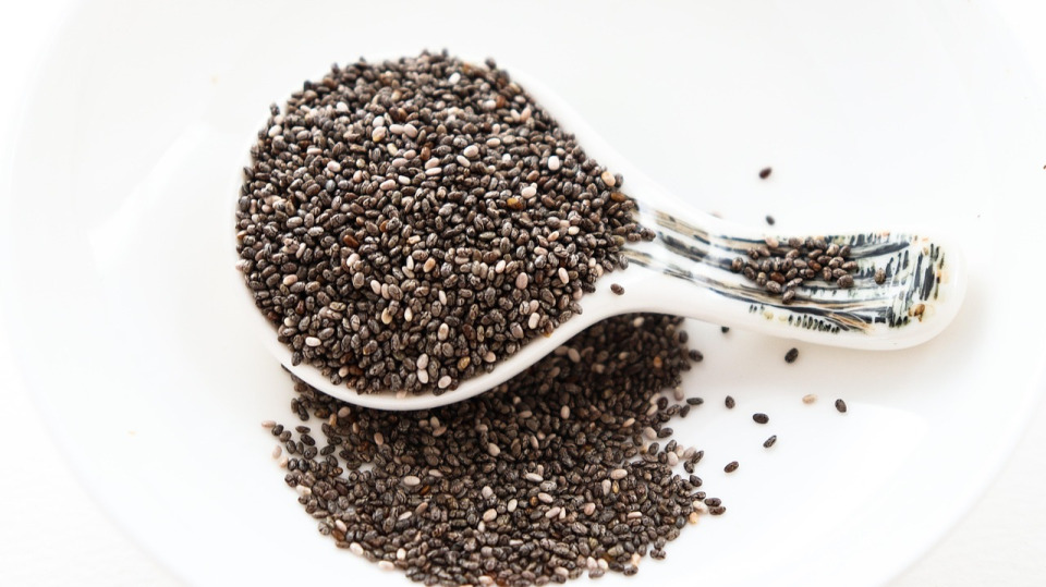 Rustic spoon overflowing with hemp seeds on a dark background