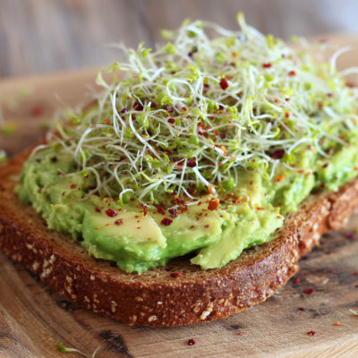 Avocado toast topped with sprouts.