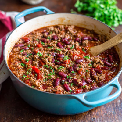 A bowl of beef chili with toppings.
