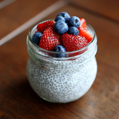 A jar of chia seed pudding with berries on top.