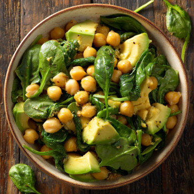A vibrant bowl with chickpeas, avocado, and spinach, on a white background with a NutrientShield logo.