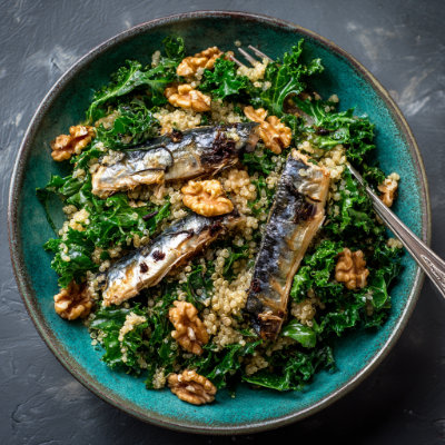 A bowl with grilled mackerel, kale, and quinoa, on a white background with a NutrientShield logo.
