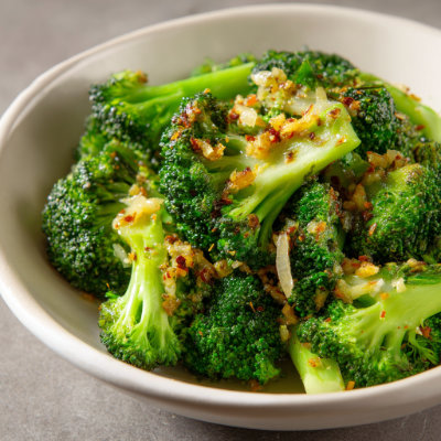 A bowl of steamed broccoli with garlic.